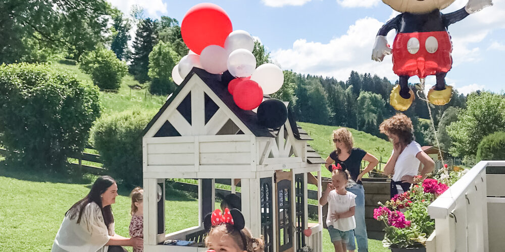 Mickey mouse birthday party with kids and adults outside.