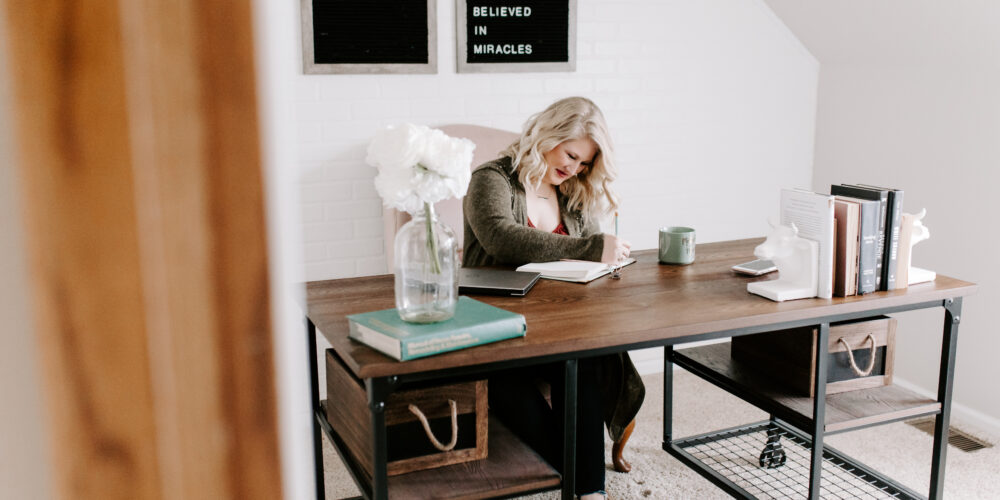 Woman working at desk determining what type of business to start.