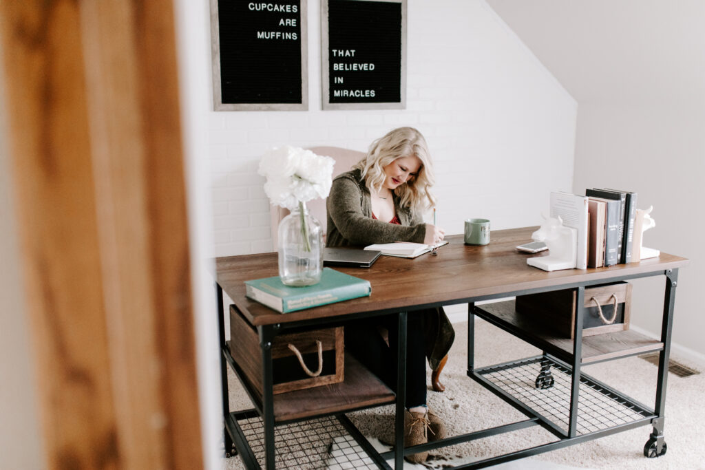 Woman working at desk determining what type of business to start. 