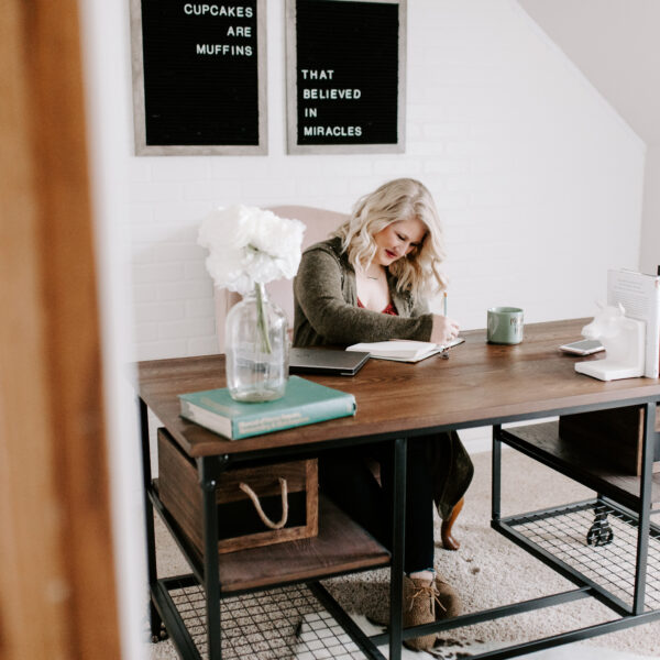 Woman working at desk determining what type of business to start.