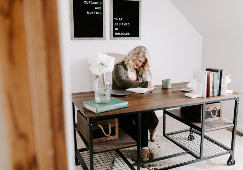 Woman working at desk determining what type of business to start.