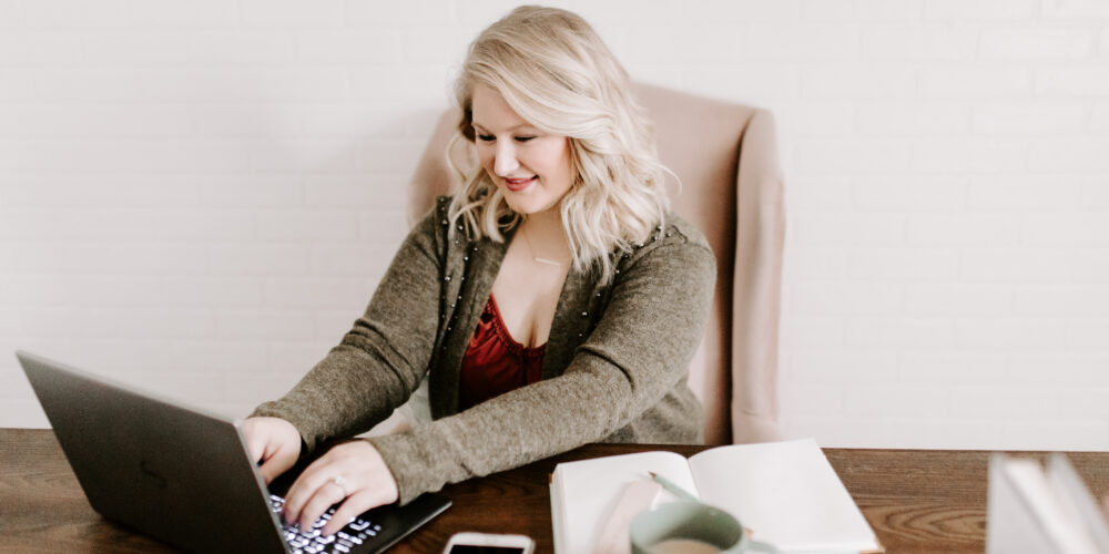 Woman working on computer determining what type of business to start.