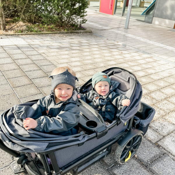 Two kids in veer stroller.