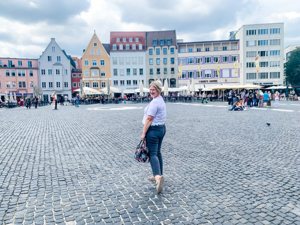 Woman in front of german buildings - learn to love your body. 